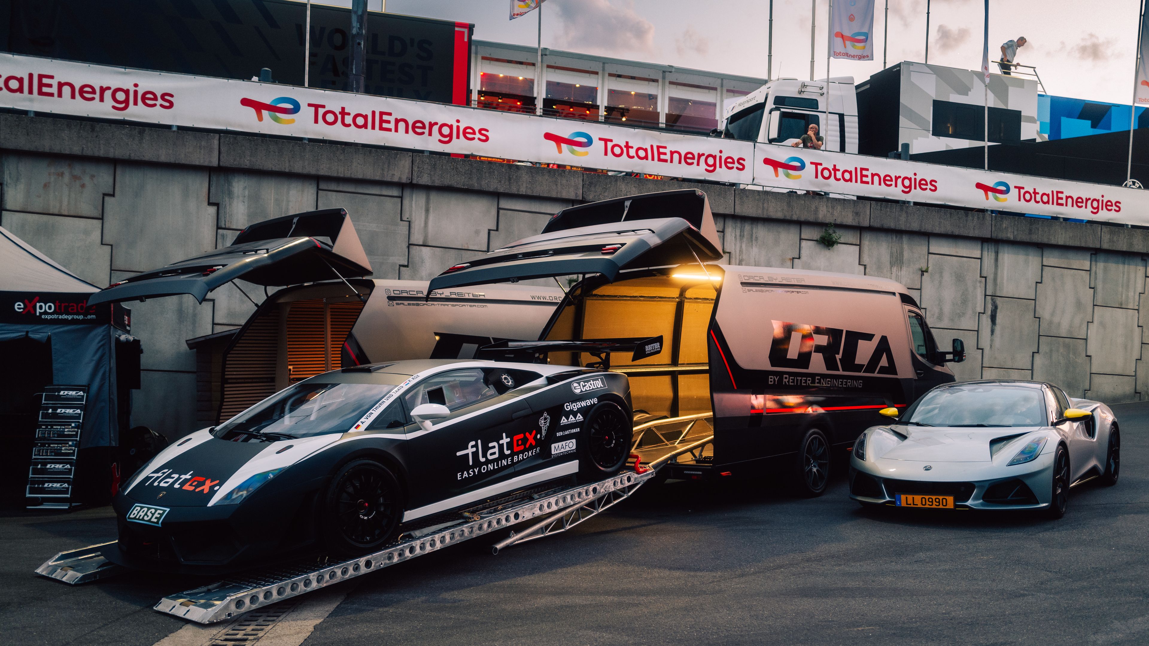 Seitenansicht ORCA Leichtbautransporter mit ausgefahrener Laderampe, auf der Lamborghini Gallardo steht